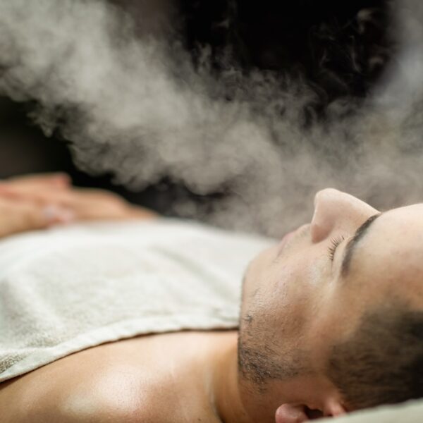 Man enjoying a beauty treatment with an ozone facial steamer