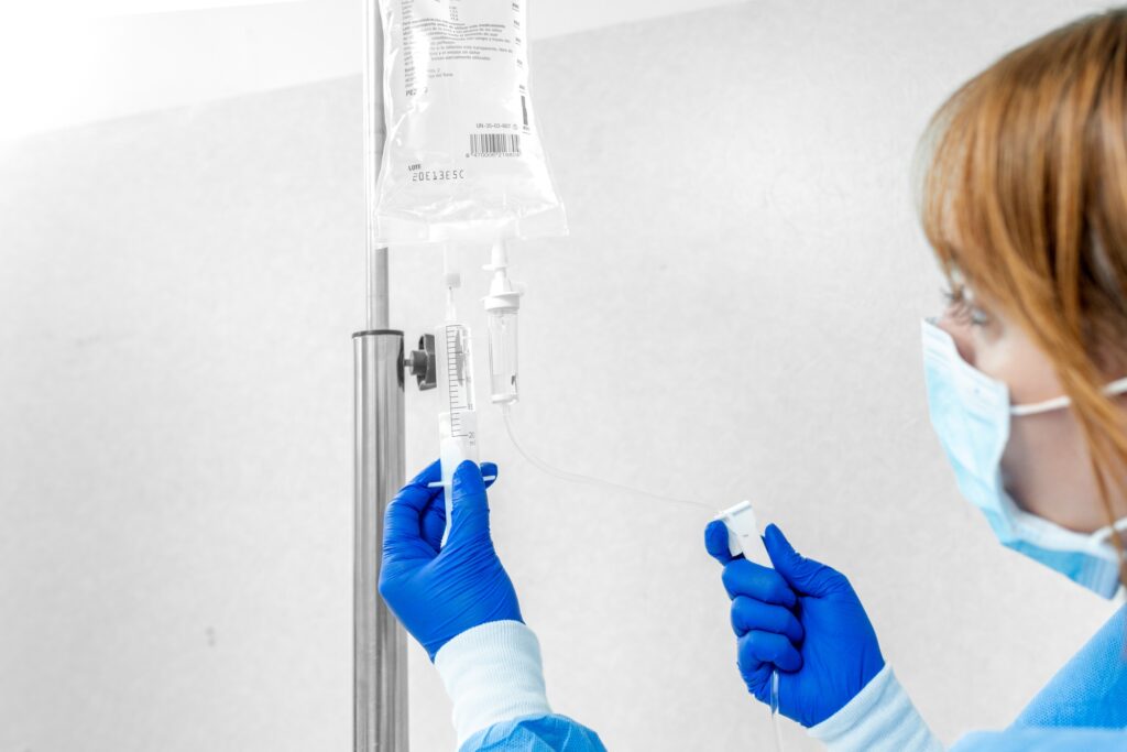 Unrecognizable Doctor or Nurse Sets Up Serum for Patient”