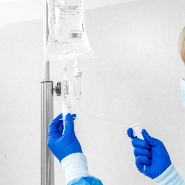 Unrecognizable Doctor or Nurse Sets Up Serum for Patient”